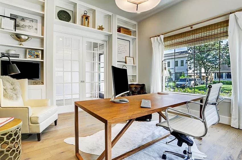 Home office with built in bookshelves above french doors