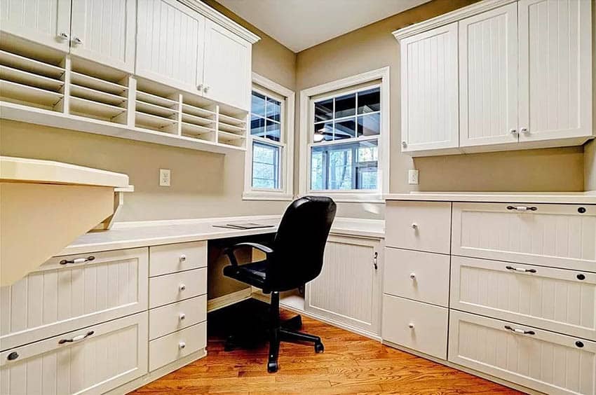 Home office with built in desk and cabinets