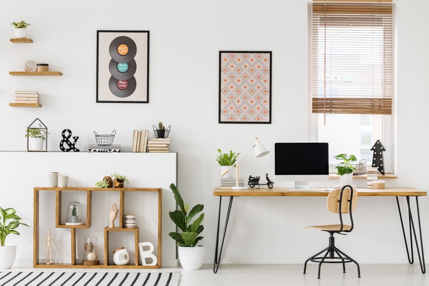 Oficina en el hogar con ventana, mesa de computadora, silla, disco de vinilo como decoración de pared y estantes flotantes