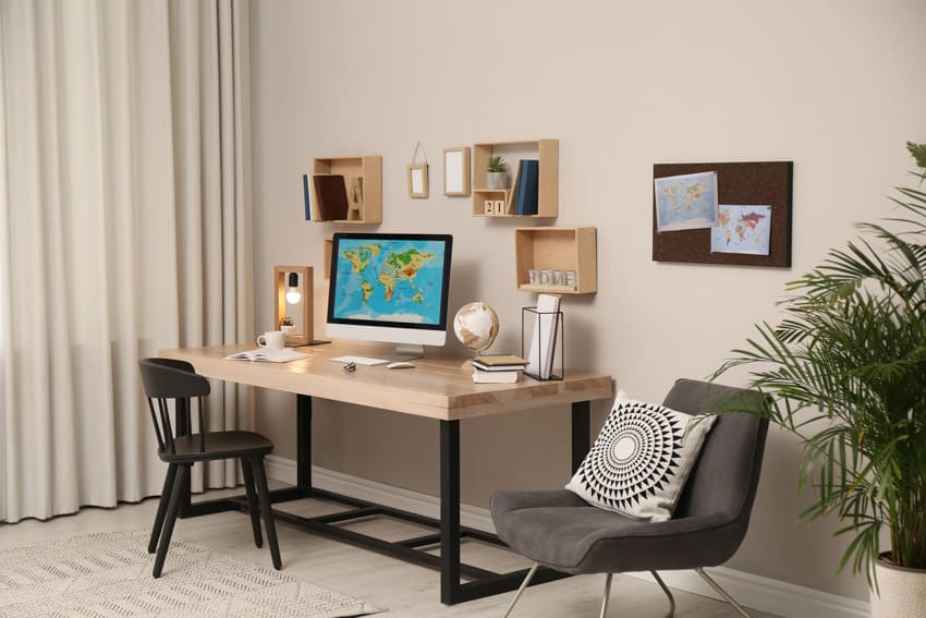 Oficina en el hogar con marco de madera, decoración de pared, mesa, silla, cortina y planta de interior