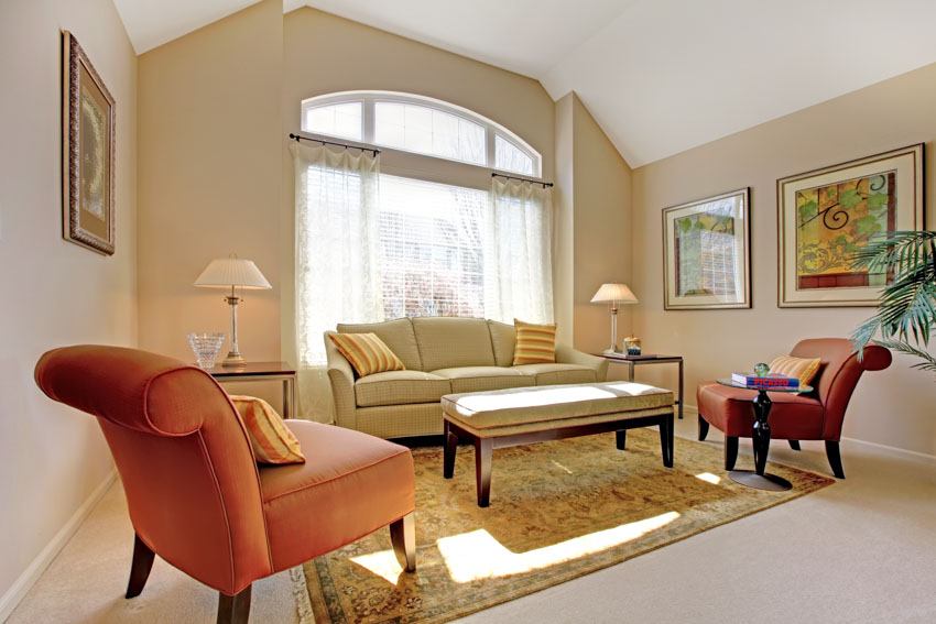 Sala de estar con sillas decorativas de color naranja, lámparas de sofá, alfombra y cortinas en las ventanas
