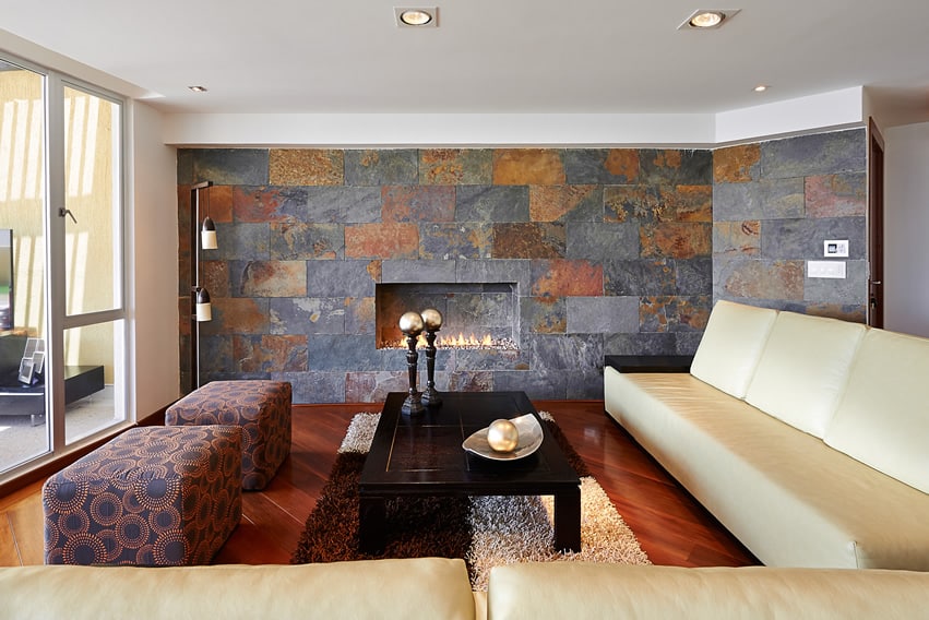 Sala de estar con pared decorativa de piedra y piso de madera