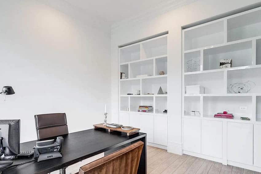 Oficina en casa moderna con armarios de librería empotrados en blanco