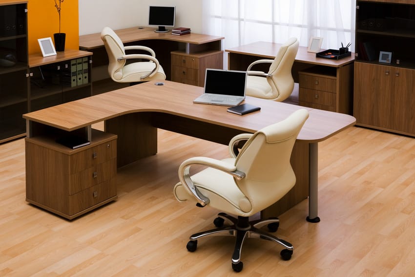 Sillones de bucle blanco en el interior de la oficina con escritorios y pisos de madera